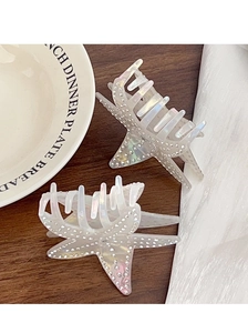 Detailed close-up of starfish hair clips with colorful rhinestones on a pearlescent finish