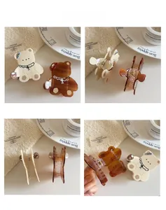 Vue détaillée des pinces à cheveux ours crème et ambre avec motifs de nœuds et dentelle