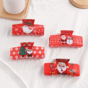 Vue détaillée de quatre pinces à cheveux rouges de Noël avec motifs de Père Noël festifs