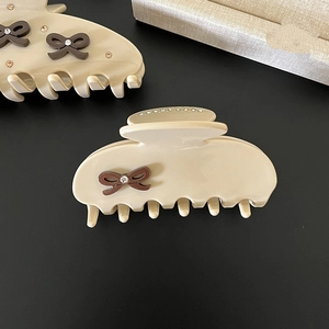 Detail of coffee brown bow hair claw with sparkling rhinestones and acetate finish