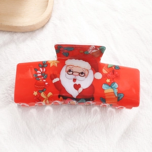 Détail d'une pince à cheveux de Noël rouge avec Père Noël et motifs festifs colorés