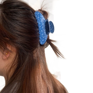 Blaue Haarklammer aus Acetat mit weißen Sternen an einem Model für schickes Haarstyling