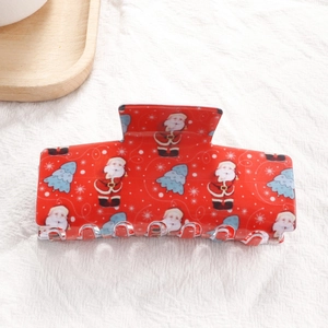 Détail de la pince à cheveux rouge de Noël avec motifs de Père Noël et flocons de neige