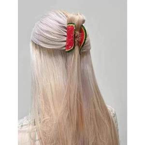 Pince à cheveux pastèque sur cheveux blonds pour une coiffure mi-haute stylée
