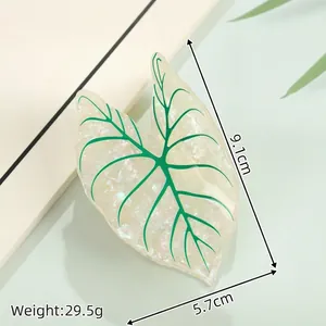 Detail view of leaf-shaped acetate hair claw with green veins and glitter finish, 9.1cm
