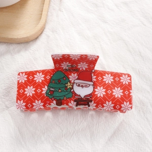 Détail d'une pince à cheveux rouge de Noël avec motif Père Noël et flocons de neige