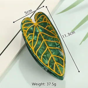 Leaf-shaped acetate hair claw clip in dark green with yellow veins, 11.3cm length