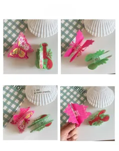 Detailed macro view of pink butterfly and green lobster hair claws with metal spring