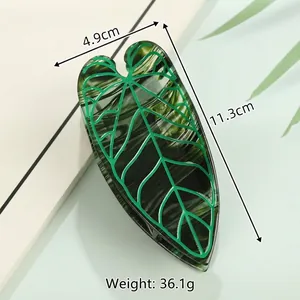 Detail of leaf-shaped hair claw clip with green marble texture and 11.3cm size dimensions
