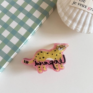 Detailed view of yellow leopard pattern acrylic hair claw clip on lifestyle background