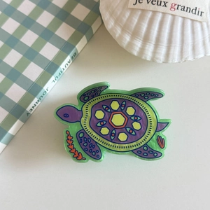 Detail of colorful turtle-shaped hair claw made of patterned acetate with glossy finish