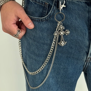 Close-up of double-layer metal pants chain with rhinestone gothic cross on blue jeans