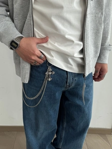 Detail of silver cross pant chain with rhinestones and matching hollow pattern ring