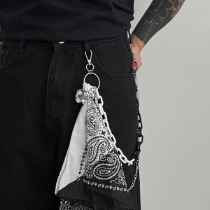 Detail of hip hop pants chain with silver hooks and black and white paisley bandana charm
