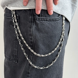 Close-up of double-layer silver metal trouser chain with heavy industrial links on denim