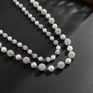 Detailansicht der zweilagigen Halskette mit weißen Perlen und Strass-Kugeln