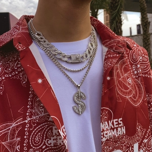 Close-up of hip hop jewelry set with silver iced out cuban link and dollar sign pendant