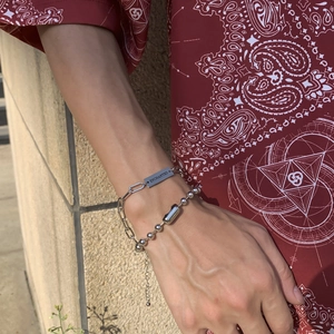 Detail of silver link bracelets with 'ENCHANTED' engraving on rectangular plaque