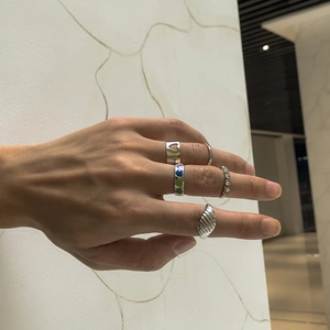 Dettaglio del set di cinque anelli d'argento con cuore traforato e strass lucidi