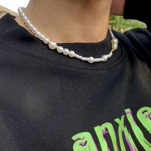 Heren parelketting met gouden metalen kralen gedragen op een zwart sweatshirt