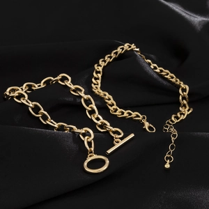Detailed macro view of gold plated Cuban chain and OT toggle clasp on black silk fabric