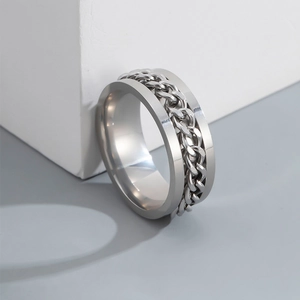 Macro detail of men's silver spinner ring featuring a rotatable Cuban link chain inlay