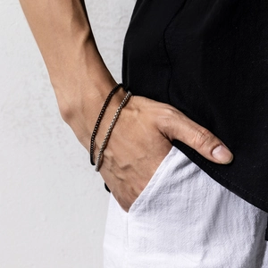 Close-up of double-layered men's bracelet with black matte and silver chain on wrist