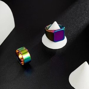 Macro detail of rainbow plated square signet and flat band rings for men in stainless steel