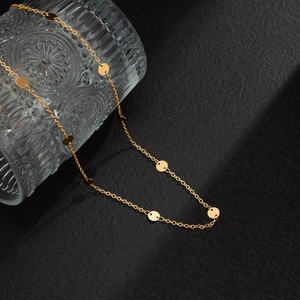 Macro shot of minimalist gold waist chain with shiny sequins on glass and dark background