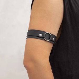 Dettaglio del bracciale punk in pelle PU nera con anello di metallo e rivetti argento