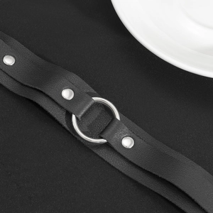 Dettaglio del bracciale in pelle PU nera con anello in metallo lucido e rivetti argentati
