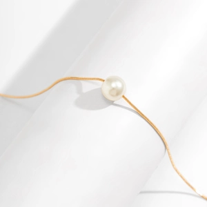 Minimalistische Perlenkette mit einer weißen Perle an einer goldenen Schlangenkette