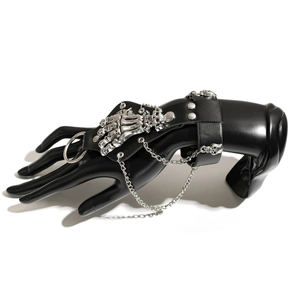 Détail d'un bracelet punk gothique avec crâne d'argent et main squelette sur cuir noir