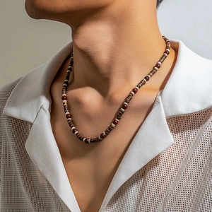 Detailed close-up of handmade bohemian wood beads and coconut shell slices on men's necklace