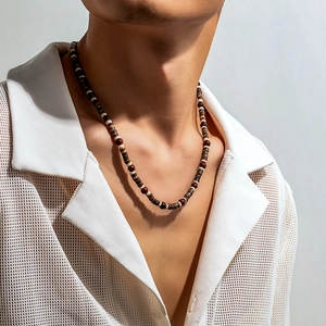 Bohemian men's beaded necklace with brown wood and white beads worn on a model