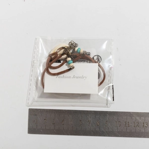 Detalle del collar de concha con cordón de terciopelo y cuentas turquesas empaquetado