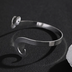 Dettaglio del bracciale a serpente d'argento con texture a squame e fascia regolabile