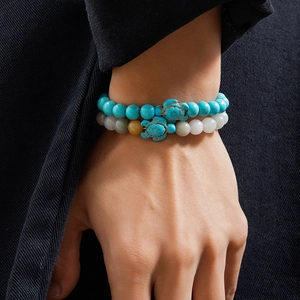 Detail of turquoise and multi-color beaded double-layer bracelets with turtle charms