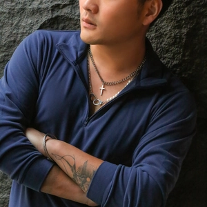Detail of men's layered necklaces with cross pendant and pearl handcuff chain