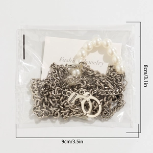 Detailed macro view of handcuff pendant with FREEDOM engraving and pearl chain necklace