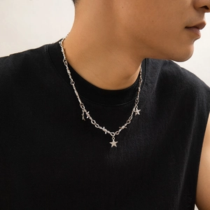 Dettaglio della collana da uomo a filo spinato con ciondoli a stella su modello