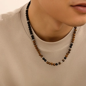 Dettaglio della collana da uomo con perle di pietra lavica nera e occhio di tigre