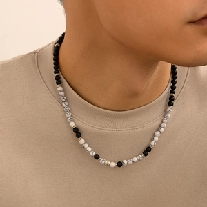 Dettaglio della collana con pietre di lava nere opache e perle bianche marmorizzate