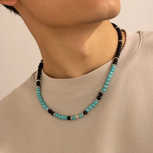 Dettaglio di una collana da uomo con pietre laviche nere, turchese e sfere d'argento