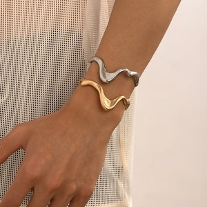 Detailed view of polished liquid metal bracelets in gold and silver finish on model