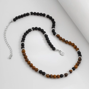 Dettaglio della collana con pietra lavica nera, perle occhio di tigre e chiusura a moschettone