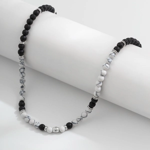 Dettaglio macro della collana da uomo in pietra vulcanica con perle di marmo bianco