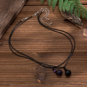 Macro detail of wax rope necklace set featuring spherical amethyst and black onyx stones