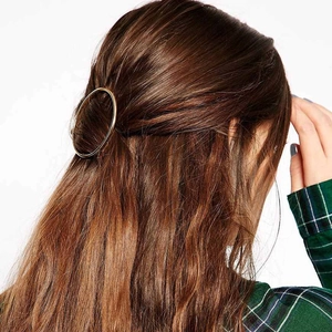 Minimalist gold hollow circular metal hair clip shown on model with brown hair