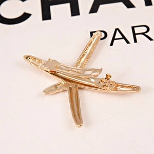 Detailed back view showing the metal spring clip mechanism of the golden starfish hair clip